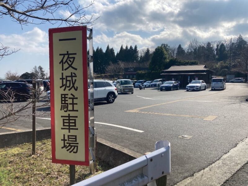 一夜城駐車場を示す看板と多くの車が停まっている風景